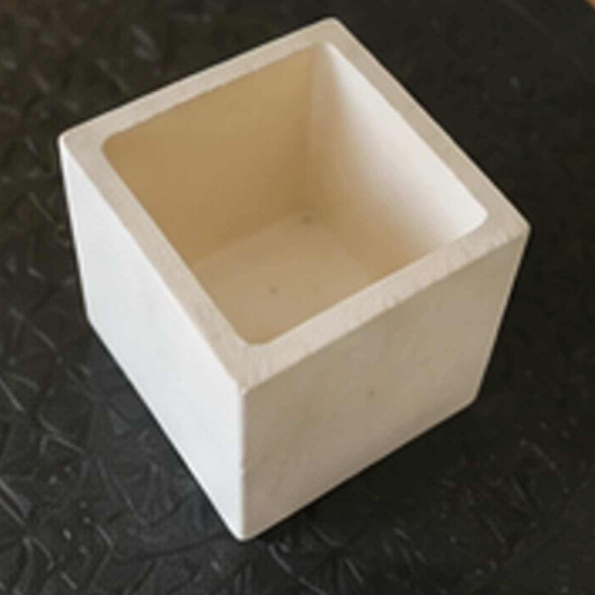 Square ceramic container on a textured black surface